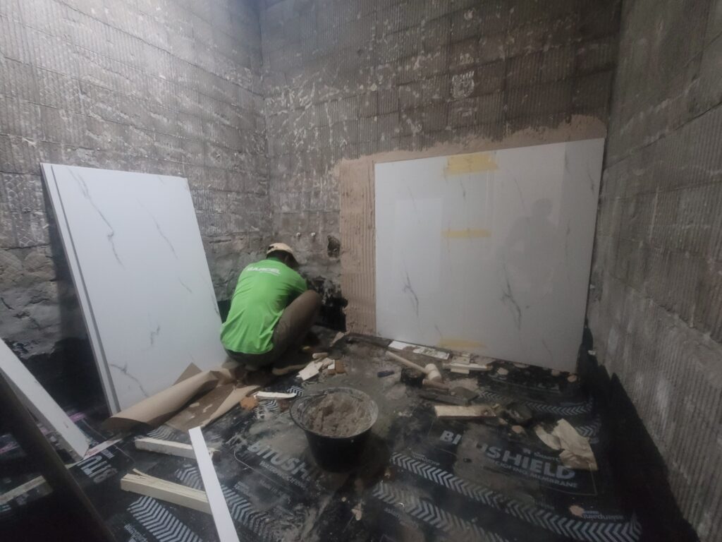 worker from www.fastfixexperts.com doing tile fixing washroom renovation work in Dubai Marina